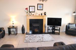 a living room with a fireplace and a tv at B2 Waterfoot Apartment in Newcastle