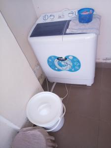 a white toilet in a bathroom with at Jayson Furnished Apartment, Nairobi in Nairobi