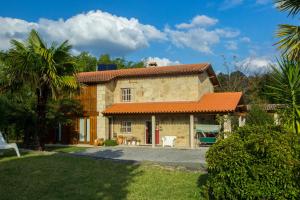 uma grande casa de pedra com um telhado laranja em Casa de Romao em Amares