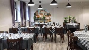 a dining room with tables and chairs and a painting at Mobile-Home 1 "Ognon" in Pesmes