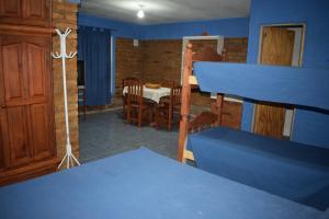 a room with blue walls and a dining room with a table at Postal Sur in Río Colorado