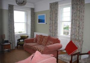 a living room with a couch and two windows at Guillemots in North Berwick