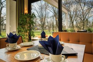 a table with blue napkins and plates on it at Reichels Parkhotel in Bad Windsheim +30 photos