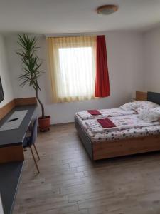 sypialnia z łóżkiem, biurkiem i oknem w obiekcie M47 Vendégház-Airport w Debreczynie
