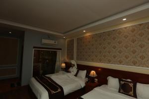 een hotelkamer met 2 bedden en een spiegel bij Sapa Unique Hotel in Sa Pa