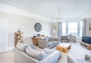a living room with couches and a tv at Firth View in North Berwick