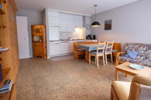 une cuisine et un salon avec une table et un canapé dans l'établissement Casa Irmella 12 - Arosa - alles komplett, à Arosa