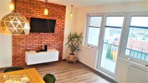 salon z ceglaną ścianą i telewizorem w obiekcie Apartament Karlikowska z widokiem na morze w mieście Sopot