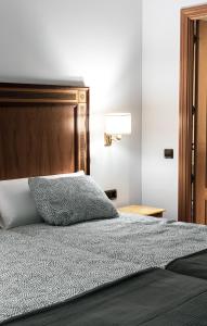 um quarto com uma cama e uma cabeceira em madeira em Estudio para dos en pleno centro de Madrid em Madri