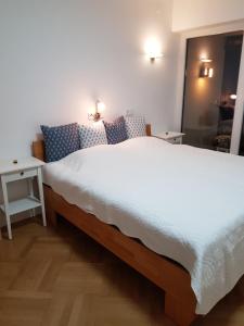 een slaapkamer met een groot wit bed en een spiegel bij Blick über Krems mit Terrasse in Krems an der Donau