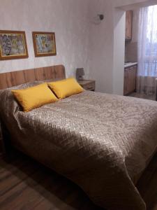 een slaapkamer met een groot bed met een geel kussen bij Мелодия прованса в старом центре in Charkov