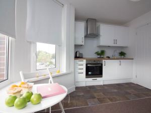 Beddoe Apartments Premier Lodge Eastleigh near Winchester and Southampton في إيستلي: مطبخ مع طاولة عليها فاكهة