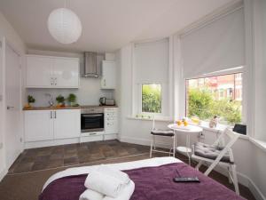 a bedroom with a bed and a table and a kitchen at Beddoe Apartments Premier Lodge Eastleigh near Winchester and Southampton in Eastleigh