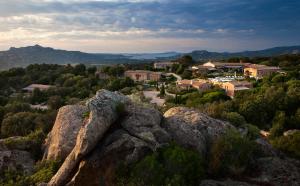 a view of a town from a mountain with rocks at Petra Segreta Resort & Spa in San Pantaleo