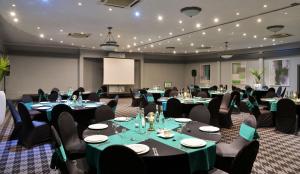 肯普顿帕克Holiday Inn Johannesburg OR Tambo Airport Hotel by IHG的配有桌椅和屏幕的会议室 更多37张照片