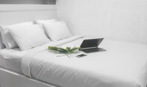 a white bed with a laptop on top of it at BIN DAOD Hotel and Restaurant in Meulaboh