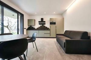 sala de estar con sofá, mesa y cocina en ApartmentsGarda - Aurora Deluxe, en Garda
