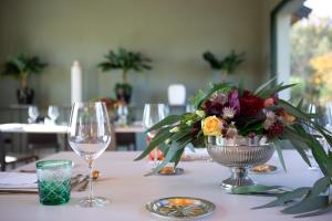a table with a vase of flowers and a wine glass at Villa Necchi alla Portalupa in Gambolò
