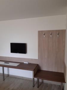a living room with a desk and a tv on a wall at M47 Vendégház-Airport in Debrecen