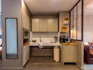 a small kitchen with a sink and a mirror at BE YOU LUXURY APART'HÔTEL - LA SO NUDE in Paris