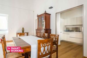 a kitchen and dining room with a table and chairs at Magione Apartment with Terrace by Wonderful Italy in Palermo