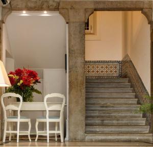 a room with a table, chairs, and a staircase at Alecrim ao Chiado in Lisbon
