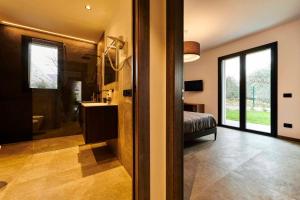 Habitación con 1 dormitorio con 1 cama y baño. en ApartmentsGarda - Aurora Deluxe, en Garda