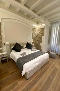 een slaapkamer met een groot bed en een stenen muur bij Casini’s house in Florence