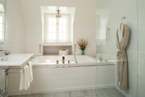 Baño blanco con bañera y lavamanos en Settlers Inn en Hawley
