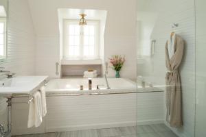 a white bathroom with a tub and a sink at Settlers Inn in Hawley