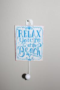 a sign that says relax yourere art in beach at B2 Waterfoot Apartment in Newcastle