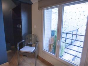 a chair sitting in front of a window at Be You Luxury Apart'Hôtel 16 in Paris