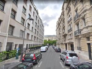 a city street with cars parked on the sides of buildings at Be You Luxury Apart'Hôtel 16 in Paris