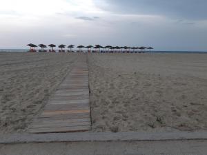 a boardwalk with umbrellas and chairs on the beach at Lidra in Korinos