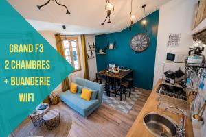 - un salon avec un canapé bleu et une table dans l'établissement "Le 44", immeuble de 2 logements neufs, garage pour le F2 uniquement, à Perpignan