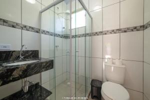 a bathroom with a toilet and a glass shower at Pousada Recanto da Lu in Paraty +143 photos
