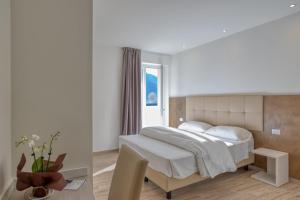 1 dormitorio con cama blanca y ventana en Barambana Rooms en Storo