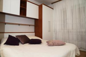 1 dormitorio con 1 cama con 2 almohadas y ventana en Apartments Bibic, en Vodice