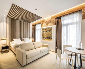 瓦伦西亚Mon Suites Benlliure的一间卧室，里面有一张床、一张沙发和一张桌子