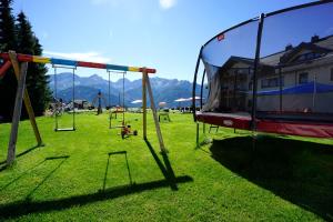 un parque infantil con columpios en un campo de césped en Apart-Hotel Alpinsonnenresidenz, en Fiss