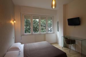 Schlafzimmer mit einem Bett, einem Schreibtisch und einem Fenster in der Unterkunft Guest House Arte in Rom