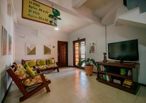 ein Wohnzimmer mit einem Sofa und einem TV in der Unterkunft Hotel Eco Atlântico in Praia do Forte