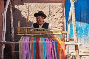 a man wearing a hat in a basket of colored fabrics at Titilaka - Relais & Châteaux in Tililaca