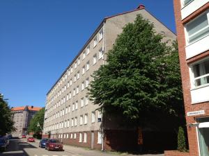 a tall building with a large tree in front of it at Eurohostel in Helsinki