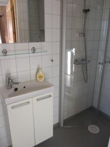 a white bathroom with a shower and a sink at Skåbu Camping in Skåbu