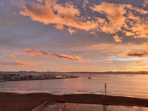 una puesta de sol sobre un cuerpo de agua con un puerto en Apartamentos Ferrán Paqui, en Roses