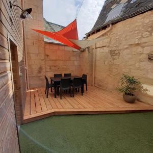 una terraza de madera con mesa y sillas. en Gîte "La Cachette Bourgueilloise" en Bourgueil