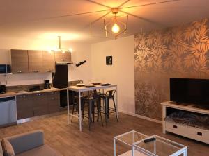 a living room with a kitchen with a table and chairs at F3 standing in Les Ulis