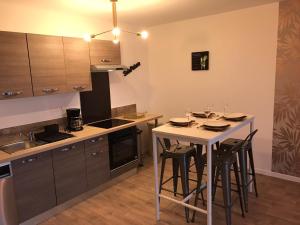 a kitchen with a table and some stools in it at F3 standing in Les Ulis