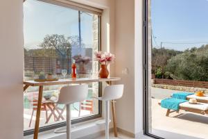 comedor con mesa y ventana grande en Canna Villa, en Vamos